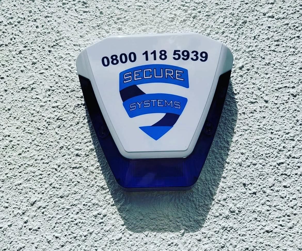 An external alarm sounder unit carrying the Secure Systems name, fitted to a rendered wall.